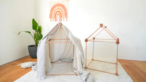 Hütte mit Tuch neben einem offenen Hausrahmen im Kinderzimmer